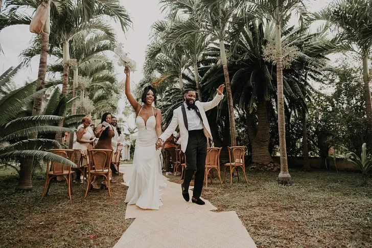 bride and groom holding hands after ceremony walking down the aisle
